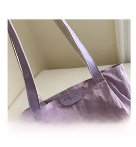 Detail view of purple tote bag with fashion tag and durable leather handles
