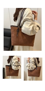 Detail view of large brown suede tote bag featuring adjustable dark leather shoulder straps
