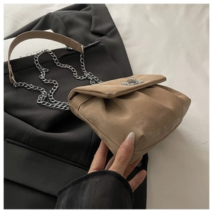 Détail du sac bandoulière en daim kaki avec bords plissés et bandoulière chaîne