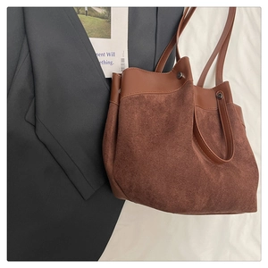 Détail de sac cabas en daim marron avec garniture en similicuir pour trajet quotidien