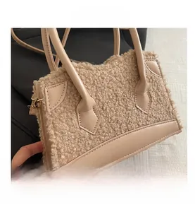 Detail of plush faux fur patchwork handbag in beige with metal hooks and soft texture
