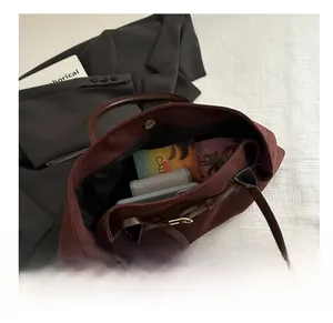 Macro shot of large burgundy faux suede tote bag interior showing spacious capacity