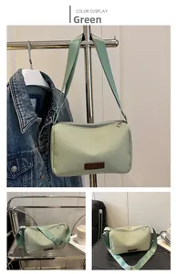 Detail view of green nylon crossbody bag showing the durable texture and fashion label