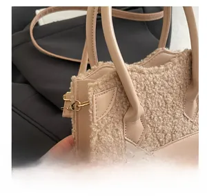 Close-up of beige faux shearling texture and gold metal hardware on crossbody bag