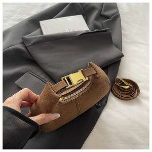 Détail d'un mini sac à main en daim marron avec boucle dorée et fermeture éclair