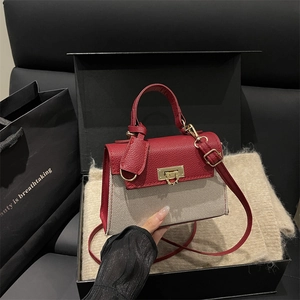 Fashionable red leather and canvas patchwork handbag with gold clasp in a gift box