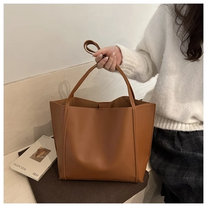 Brown vintage large capacity tote bag shown with model in casual knitted sweater