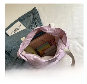 Detailed view of spacious purple tote bag showing books and umbrella for daily storage