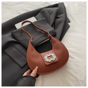 Dettaglio della borsa a mezzaluna in pelle marrone con fibbia in strass lucidi