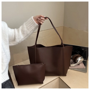 Macro shot of dark brown PU leather tote bag set including a small zippered pouch