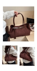 Detail of large brown suede tote bag featuring slim leather straps and metal buckle