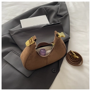 Détails d'un sac demi-lune en daim marron avec ferrures dorées et intérieur spacieux