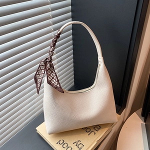 Minimalist beige hobo bag in lychee texture with elegant silk scarf on handle