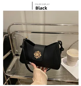 Detailed close-up of a black leather tote bag featuring a golden petal-shaped metal buckle