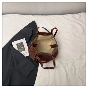 Détail d'un sac seau marron en daim et cuir avec fermoir magnétique et doublure en toile