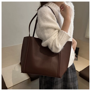 Macro detail of deep brown matte leather tote bag with sturdy straps for office commuting