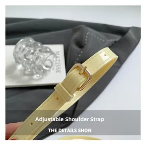 Detail of adjustable cream shoulder strap with gold buckle and fine stitching