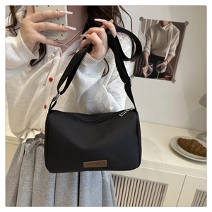 Gros plan d'un sac bandoulière noir minimaliste avec étiquette en cuir marron Fashion