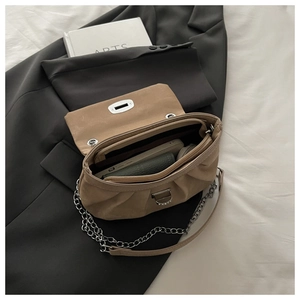 Détail intérieur du sac beige plissé montrant la poche zippée et l'espace de rangement