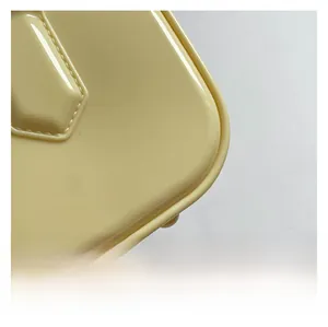 Close-up of yellow glossy patent leather bag showing rounded corners and precise stitching
