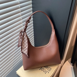 Brown lychee leather Hobo shoulder bag with elegant silk scarf on a book stack