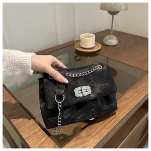 Détail du sac bandoulière noir avec texture vintage et boucle en strass étincelants
