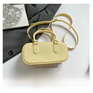 Detail view of mini cream yellow jelly pillow bag showing smooth texture and twin handles