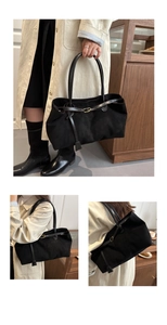 Close-up of black faux suede tote bag with long shoulder straps and metallic buckle detail