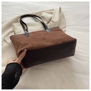 Close-up of large brown suede tote bag with reinforced base and sturdy shoulder straps
