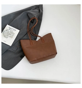 Detail of caramel brown lychee texture tote bag with slanted pocket and dual straps