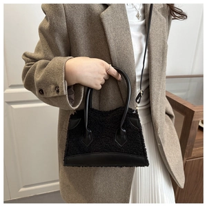 Detail of black faux shearling handbag showing rich fuzzy texture and leather stitching