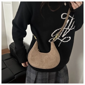 Détails du sac croissant mat montrant la texture suédée marron et boucle dorée