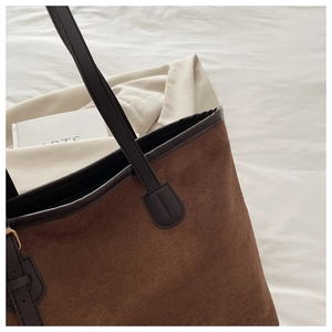 Detail of dark brown tote bag with corduroy texture and matte leather shoulder straps