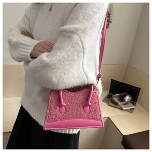 Detailed side view of pink sherpa mini bag with leather bottom and top handles