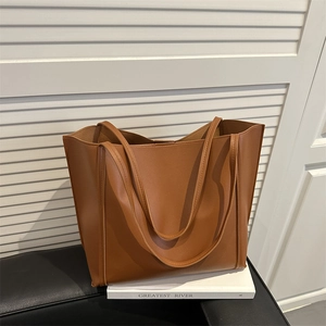 Minimalist brown large capacity tote bag with dual handles on white aesthetic books