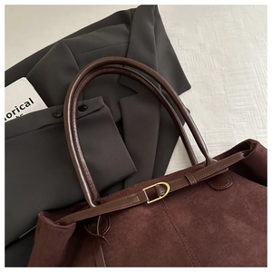 Détail du grand sac cabas en daim marron avec bandoulière en cuir et boucle dorée