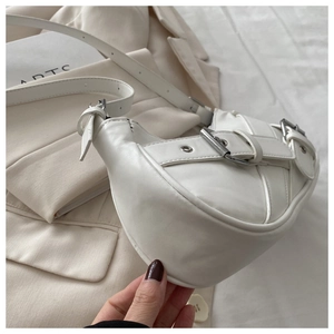 Detail of white leather crescent shoulder bag with retro buckle straps and adjustable strap