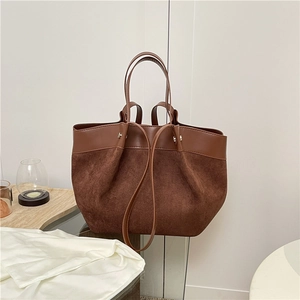 Sac fourre-tout en cuir marron et daim avec fines bretelles dans un décor minimaliste