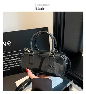 Detailed macro view of black patent leather handbag with golden hardware and handles