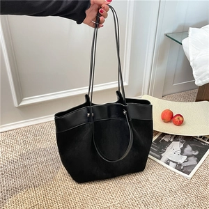 Sac fourre-tout noir moderne avec textures cuir mixtes et grande capacité en scène de vie