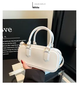 Detailed view of white glossy leather Boston bag with gold hardware and dual handles
