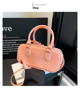 Close-up of a pink glossy patent leather bowling bag on a display stand with twin handles