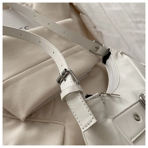 Detail of white PU leather shoulder bag with silver buckles and metallic eyelets
