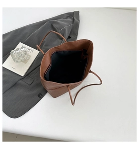 Detailed view of brown litchi grain leather tote bag with spacious interior and zipper pocket