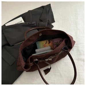 Détail d'un grand sac cabas marron foncé montrant l'intérieur spacieux et la fermeture aimantée