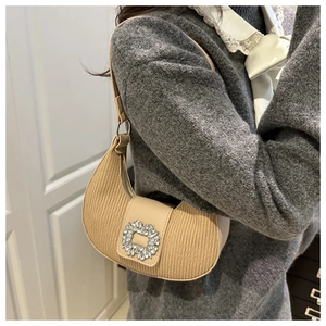 Dettaglio borsa hobo beige plissettata con grande fibbia di cristallo chic