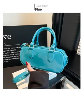 Detailed view of glossy blue jelly pillow bag with metallic gold zippers and strap