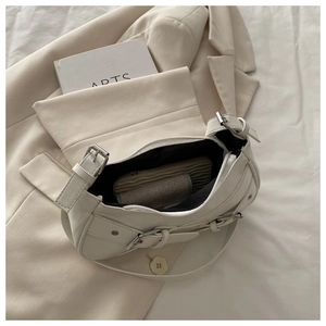 Interior detail of white saddle underarm bag showing spacious storage for essentials