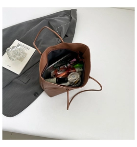 Detailed top view of a brown pebbled leather tote bag showing spacious interior with essentials