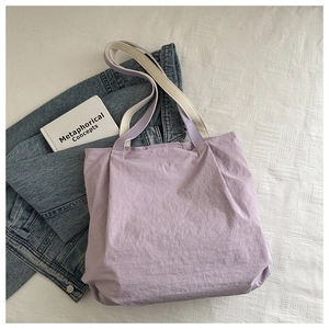 Close-up of lavender tote bag featuring dual contrast shoulder straps and textured fabric